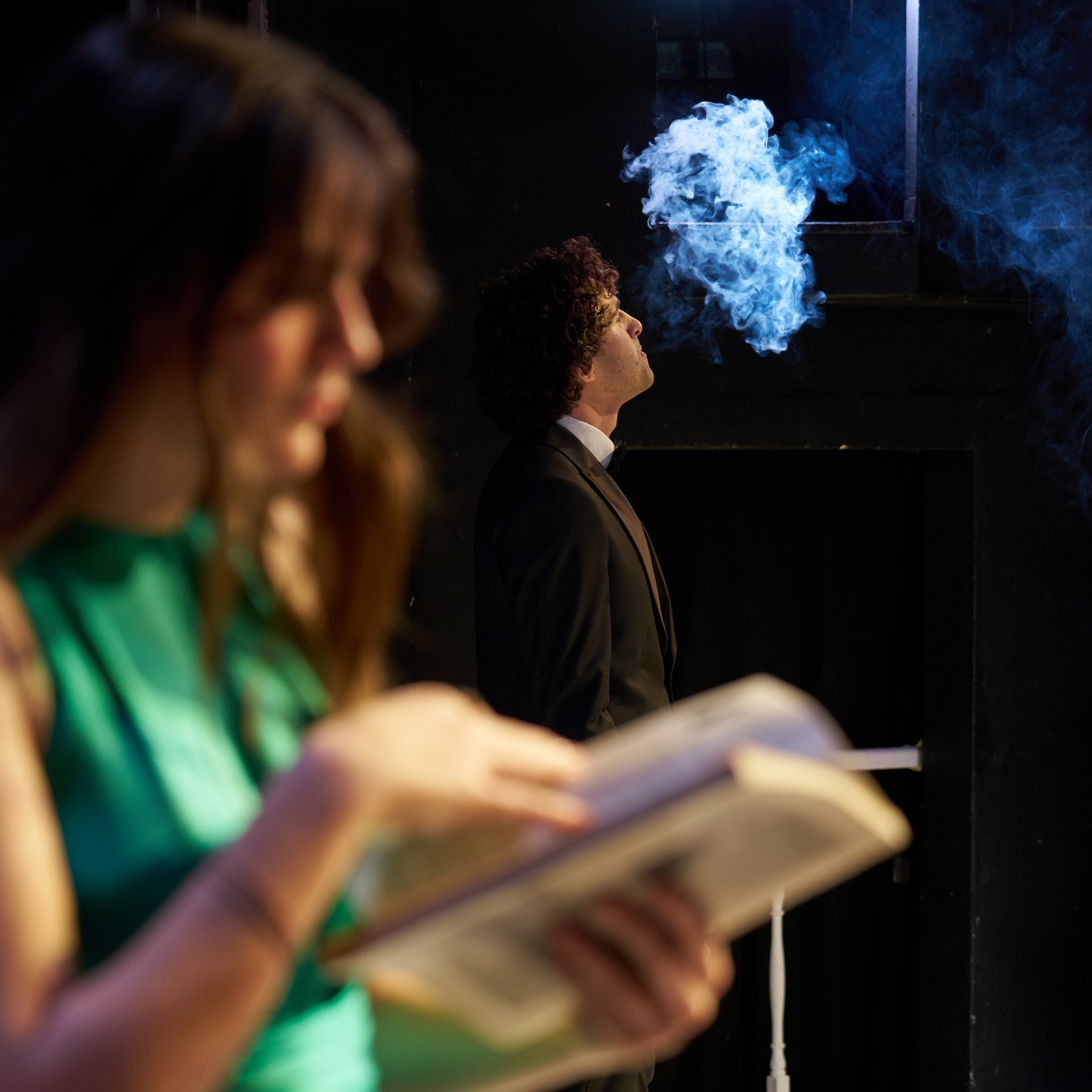 Leo Morad on stage blowing a smoke ring, Private Lives